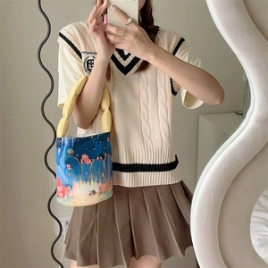 Close-up of blue cartoon bucket bag with yellow handles and cute illustration patterns
