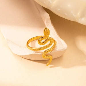 Detailed view of a gold-toned snake ring with intricate textures on textured plaster stone