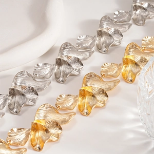 Textured metal ginkgo leaf necklace in gold and silver finish on white background