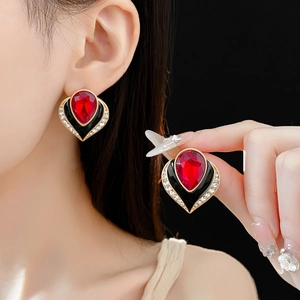 Detail of vintage heart earring with red gemstone, black enamel and crystals