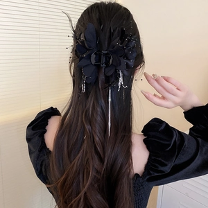 Pince à cheveux fleur noire avec franges en diamants portée par un mannequin en gros plan