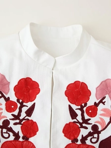 Detail of floral embroidery and mandarin collar on a white cotton casual blazer jacket