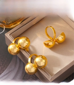 Detail of 18k gold plated open rings showing PVD electroplated finish and spherical design