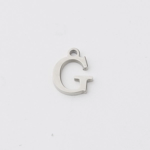 Close-up of silver stainless steel letter G pendant with mirror finish and connector ring