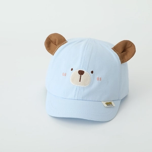 Détail d'une casquette bébé avec oreilles d'ours 3D et broderie sur tissu en coton bleu