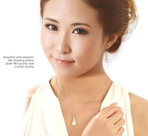 Detail of silver drop earrings and necklace set with white cat eye stone on a model