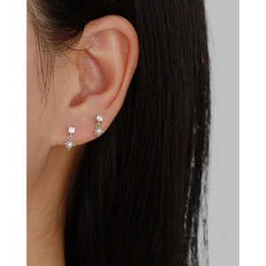 Detail of S925 silver pearl stud earrings with zircon inlay worn on double ear piercings