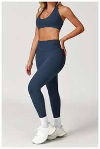 Detail of high-waist yoga pants and halter top set in navy blue with body-shaping fit