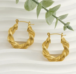 Detailed view of 18k gold plated stainless steel twisted hoop earrings on white stand