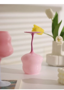 Close-up of pink macaron glass with twisted stem and elegant wavy flower shape cup