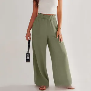 Dettaglio di pantaloni larghi in lino verde salvia con vita alta elastica a volant