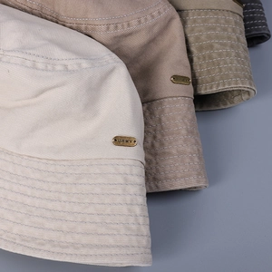 Classic washed cotton bucket hats in neutral tones with vintage metallic logo detail