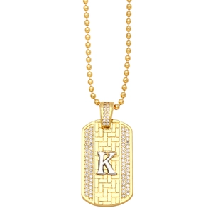 Macro detail of gold-plated K letter pendant with micro-pave cubic zirconia stones