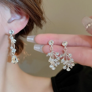Elegant silver earrings with sparkling leaf and teardrop diamond patterns in rhinestones