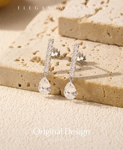 Macro shot of silver drop earrings with long bar diamonds and sparkling teardrop stones