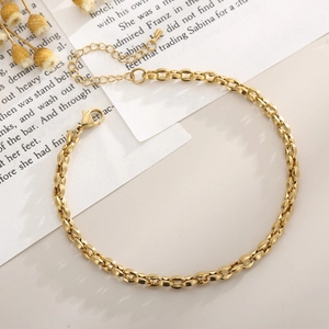 Detail of 18K gold plated titanium steel anklet with lobster clasp on vintage background