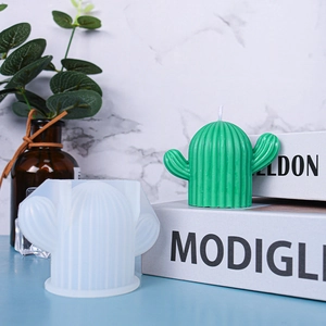 Detail showing white silicone cactus mold and finished green candle on a modern desk
