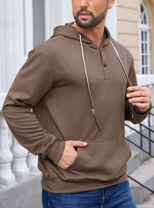 Close-up of brown waffle texture fabric on men's hoodie with white drawstring and pocket