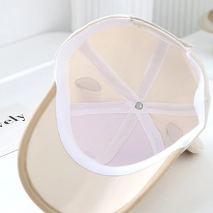 Internal view of beige kids baseball cap showing reinforced seams and breathable eyelets