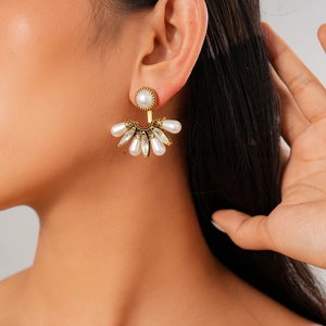 Gros plan d'une boucle d'oreille baroque en forme d'éventail avec perles et cristaux