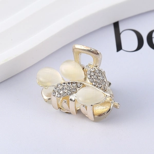 Detail of leaf design hair claw clip with champagne gold metal and opal rhinestones