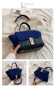 Detail of navy suede and black crocodile leather patchwork handbag with gold metal lock