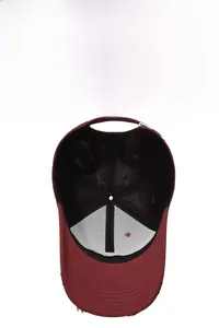 Detail of burgundy baseball cap interior with stitching, sweatband, and distressed brim