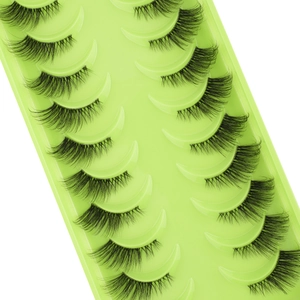 Macro detail of ten pairs of dense black half-lashes arranged in a green storage tray