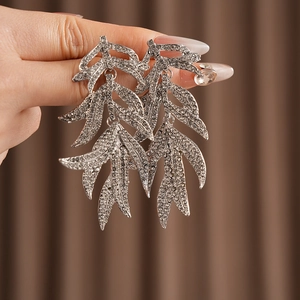 Detailed view of silver leaf tassel earrings with sparkling crystals and long drop design