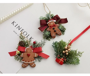 Detailed view of gingerbread man resin ornaments with red bows and faux pine needles