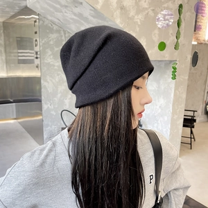Détail de la maille fine et de la coupe tombante du bonnet noir porté par un mannequin