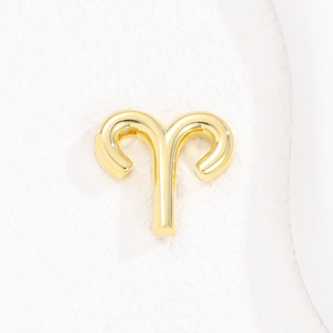 Macro shot of polished gold Aries zodiac pendant with a smooth balloon bubble finish