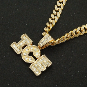 Close-up of gold Cuban chain and RICH pendant featuring square set pavé diamonds