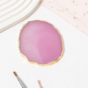 Pink agate resin nail palette with gold edges and art brushes on white background