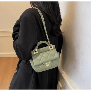 Detail of light green quilted leather bag with gold chain strap and metal lock