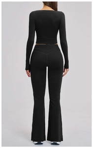 Detail view of the back of a black long sleeve yoga set featuring high waist flared pants