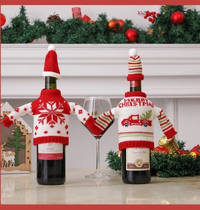 Detail of Christmas wine bottle covers featuring knitted red snowflake and white truck motifs