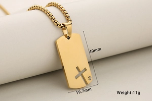 Détail macro du pendentif croix en acier doré avec dimensions et chaîne à mailles carrées