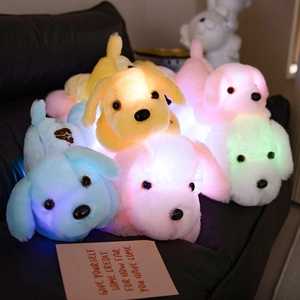 Luminous plush puppy dog dolls with colorful LED lights on a dark sofa for kids
