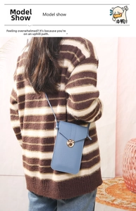 Rear view of a blue PU leather crossbody phone bag with gold twist lock on a model