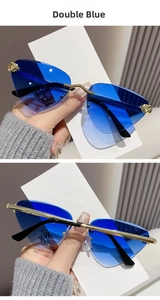 Close-up of frameless geometric cat eye sunglasses with gradient blue lenses and gold metal frame