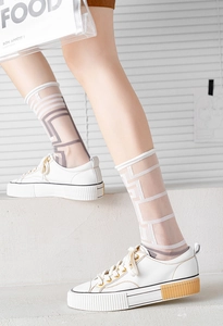 Detail of transparent glass silk socks with geometric lines and thick-soled sneakers