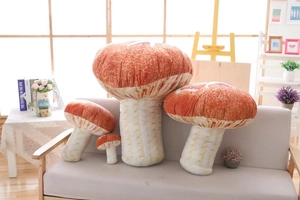 Detail of four mushroom plush pillow shells in various sizes on a soft grey sofa