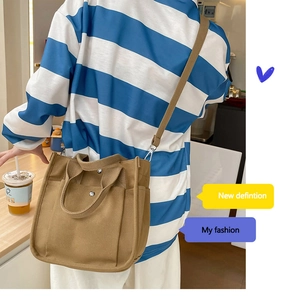 Detail of canvas tote bag with metal button pocket and adjustable shoulder strap