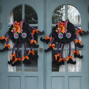 Pair of creative Halloween spider wreaths featuring colorful bows and striped legs on a door