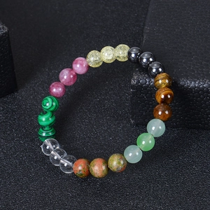 Macro shot of 8mm tiger eye and green aventurine beads on a black textured jewelry display