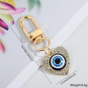 Detailed view of heart-shaped blue evil eye keychain with rhinestones and size dimensions