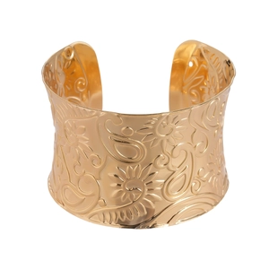 Golden wide open cuff bracelet with embossed floral and paisley patterns on a white background