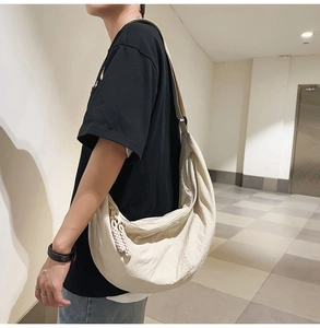 Détail du sac croissant en nylon beige avec bandoulière réglable et tirette tissée