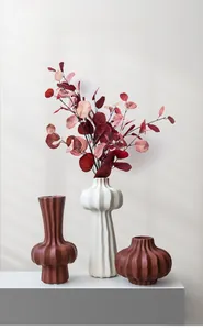Detail view of modern matte ceramic vases with vertical texture in warm brown and beige